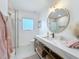 Bathroom featuring a marble countertop vanity, gold fixtures, and a walk-in shower with glass door at 2308 Tulip St, Sarasota, FL 34239