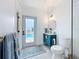 Stylish bathroom with blue vanity, round mirror, and poolside access at 2308 Tulip St, Sarasota, FL 34239
