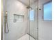 Shower featuring marble tile surround, gold fixtures including shower head and handheld wand, and a built-in niche at 2308 Tulip St, Sarasota, FL 34239