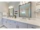 Modern bathroom with dual sinks, white cabinets, quartz countertops, and framed mirrors with decorative lighting at 2322 5Th E St, Palmetto, FL 34221