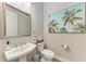 Powder room with pedestal sink, toilet, and framed print of palm trees at 2322 5Th E St, Palmetto, FL 34221