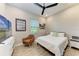 Cozy bedroom features a ceiling fan, bright window, wood-look flooring, and beach-themed decor at 2322 5Th E St, Palmetto, FL 34221