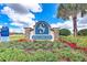 Community sign for Sanctuary Cove, surrounded by colorful landscaping under a sunny sky at 2322 5Th E St, Palmetto, FL 34221