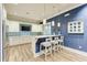 Modern kitchen area with white cabinets, pendant lighting, counter seating, and a stylish blue accent wall at 2322 5Th E St, Palmetto, FL 34221