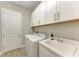 Bright laundry room featuring a utility sink, modern cabinets, and a washer and dryer at 2322 5Th E St, Palmetto, FL 34221