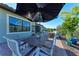 Outdoor patio dining area featuring a dark wood table, chairs, umbrella, and views of the backyard and landscaping at 2322 5Th E St, Palmetto, FL 34221