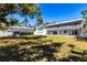 Wide backyard view featuring a two-story home with a balcony, a storage building, and a lush lawn at 2422 53Rd St, Sarasota, FL 34234