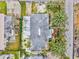 Overhead view of the home featuring a gray roof, tropical trees, back deck, and surrounding yard at 256 144Th Ave, Madeira Beach, FL 33708