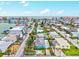 An aerial view showcasing the bright blue home and surrounding neighborhood with water views at 256 144Th Ave, Madeira Beach, FL 33708