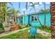 Backyard featuring a cozy deck, lush greenery, and a charming blue home, great for outdoor entertaining at 256 144Th Ave, Madeira Beach, FL 33708