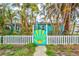 Charming home with a bright blue exterior, surrounded by lush palm trees, and featuring a whimsical gate at 256 144Th Ave, Madeira Beach, FL 33708
