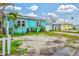 Bright turquoise single story home featuring an ample gravel front yard and driveway at 256 144Th Ave, Madeira Beach, FL 33708
