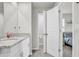 Bright bathroom with white cabinets, granite countertop, and an open doorway to the Primary bedroom at 2718 Chestnut Creek Pl, Brandon, FL 33510