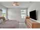 Comfortable bedroom with mounted TV and dresser and large windows at 2718 Chestnut Creek Pl, Brandon, FL 33510