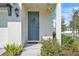 Charming home entryway featuring a stylish blue door with wreath and well-manicured landscaping at 2718 Chestnut Creek Pl, Brandon, FL 33510