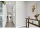 Bright hallway featuring neutral walls, tile floors, and a decorative table with flowers and botanicals at 2718 Chestnut Creek Pl, Brandon, FL 33510