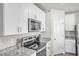 Close-up of the kitchen features stainless steel appliances, granite countertops, and white cabinetry at 2718 Chestnut Creek Pl, Brandon, FL 33510