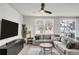 Spacious living area featuring a large TV, stylish furniture, and a large window offering natural light at 2718 Chestnut Creek Pl, Brandon, FL 33510