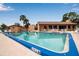 Community pool featuring clear water, patio seating, and a nearby recreation building for residents' enjoyment at 2808 60Th W Ave # 1722, Bradenton, FL 34207