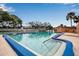 Community pool features clear water, depth markings, surrounding tennis court, and comfortable lounge seating at 2808 60Th W Ave # 1722, Bradenton, FL 34207