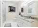 Well-lit bathroom featuring double vanity with granite countertop, shower, and elegant artwork at 282 Rue Des Lacs, Tarpon Springs, FL 34688