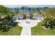 Stunning waterfront home featuring a circular driveway with a fountain and lush tropical landscaping at 282 Rue Des Lacs, Tarpon Springs, FL 34688