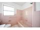 Bathroom featuring pink tile, bathtub, and a window providing natural light at 3011 Bougainvillea St, Sarasota, FL 34239