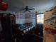Bedroom with a black-and-white plaid bedspread, ceiling fan, and small pictures on the wall at 303 60Th W Ave, Bradenton, FL 34207