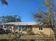 Cozy single story home featuring a well-kept yard with mature trees and tan siding at 303 60Th W Ave, Bradenton, FL 34207