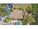 Expansive aerial view of a tiled-roof home boasting a pool, lush landscaping, and serene waterfront access at 3107 Pine St, Bradenton, FL 34208