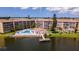 Aerial view of community shows pool, a fishing dock, and multiple buildings with scenic lake at 3525 Lake Bayshore Dr # 103J, Bradenton, FL 34205