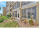 Building exterior with screened balconies, garden, and an easy access door to the community grounds at 3525 Lake Bayshore Dr # 103J, Bradenton, FL 34205