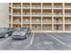 The building's facade shows parking spaces with car and balcony, offering convenient city living at 3525 Lake Bayshore Dr # 103J, Bradenton, FL 34205