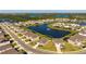 Aerial view of a residential area featuring homes surrounding a beautiful pond with a fountain at 3677 Turning Tides Ter, Bradenton, FL 34208