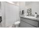 Well-lit bathroom featuring a shower with curtain, granite countertop, and coordinated gray and white decor at 3677 Turning Tides Ter, Bradenton, FL 34208