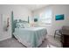 Comfortable bedroom featuring a decorative headboard, soft blue bedding, and plantation shutters for natural light at 3677 Turning Tides Ter, Bradenton, FL 34208