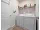 Functional laundry room with washer, dryer, shelving, and a convenient hanging rod for clothing care at 3677 Turning Tides Ter, Bradenton, FL 34208
