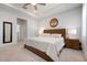 Bright main bedroom featuring carpet floors, a wooden bed frame and a view into the bathroom at 3677 Turning Tides Ter, Bradenton, FL 34208