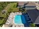 A picturesque aerial view of a community pool with sun loungers and surrounding greenery, perfect for relaxation at 3677 Turning Tides Ter, Bradenton, FL 34208