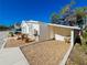This home has a white stucco exterior, brick accents, and a small covered carport with room for a chair at 4 Braden Castle Dr, Bradenton, FL 34208