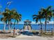Inviting waterfront pier featuring a charming gazebo and bordered by lush palm trees against a serene water view at 4 Braden Castle Dr, Bradenton, FL 34208