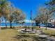 Scenic waterfront community area with American flags, picnic tables, and lush greenery on a clear sunny day at 4 Braden Castle Dr, Bradenton, FL 34208