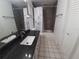 Bathroom featuring a dark granite counter, white floors and a shower with grey subway tile at 4031 Iola Dr, Sarasota, FL 34231