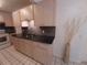 Kitchen featuring light wood cabinets, dark countertops, white appliances, and tile flooring at 4031 Iola Dr, Sarasota, FL 34231