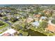 Aerial view of a residential area with lush landscaping and waterfront properties and a water feature behind the house at 417 Tortuga Dr, Nokomis, FL 34275