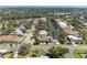 Aerial view of a single-Gathering home neighborhood on a narrow waterway with mature trees and tropical foliage at 417 Tortuga Dr, Nokomis, FL 34275
