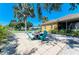 Outdoor patio with fire pit, surrounded by gravel and lush palm trees at 417 Tortuga Dr, Nokomis, FL 34275