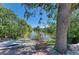 Lush backyard overlooking a serene lake, with verdant landscaping and mature trees at 417 Tortuga Dr, Nokomis, FL 34275