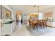 Bright dining area featuring a wooden table, chandelier, and white tiled floors at 417 Tortuga Dr, Nokomis, FL 34275