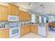 Bright kitchen featuring wood cabinets, neutral countertops, and tile backsplash at 417 Tortuga Dr, Nokomis, FL 34275